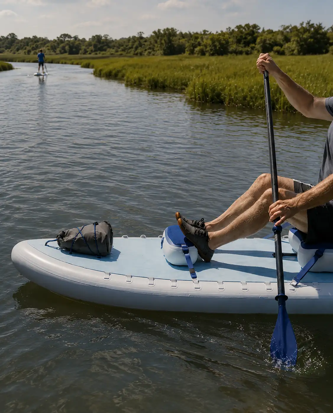 Inflatable paddleboard and water sports equipment in use on a calm river.