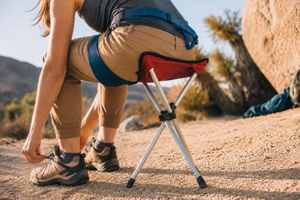 Camping Stools from China: A Sourcing Guide Hiker using a compact tripod camping stool during an outdoor break.
